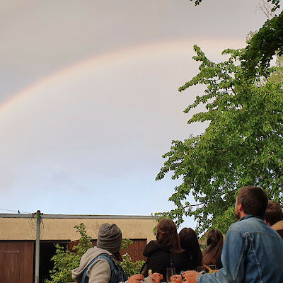 Am Gründungstag von #unteilbar in Spremberg steht ein Regenbogen über dem Treffen im Garten, Mai 2021
